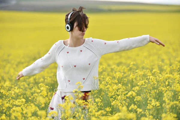 Joven mujer feliz escuchando música en auriculares al aire libre — Foto de Stock