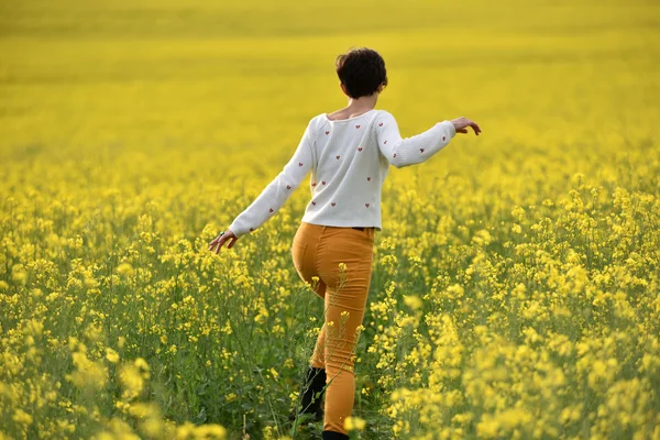 Une fille hippie qui marche dans un champ de canola. Concept de liberté — Photo