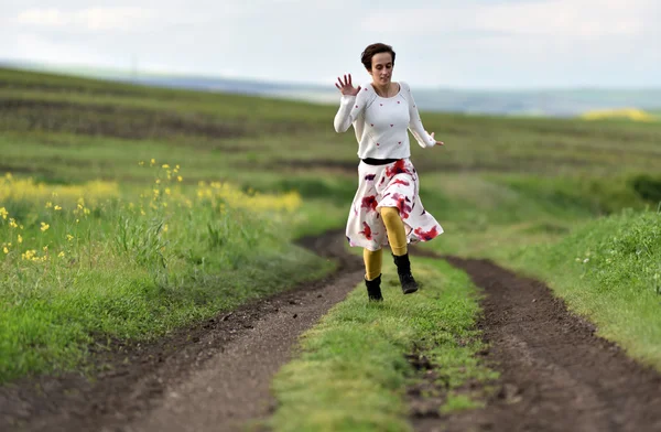 Jovem a correr numa estrada rural. Conceito de liberdade — Fotografia de Stock