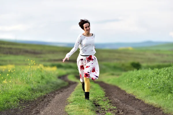 Una joven corriendo por un camino rural. Concepto de libertad — Foto de Stock