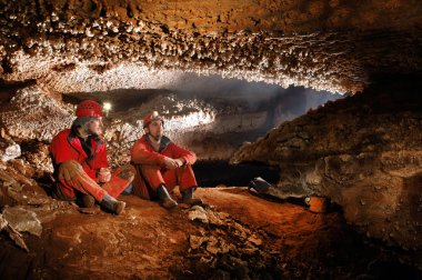 Speleologists exploring a beautiful cave clipart