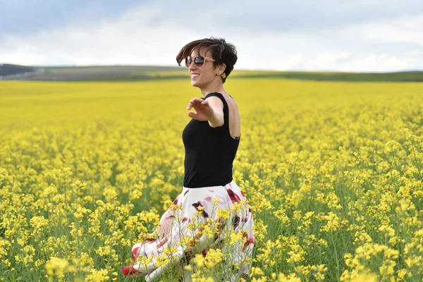 Mujer feliz animando en el campo de canola en el verano —  Fotos de Stock