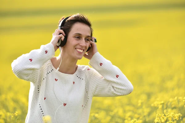 Giovane donna godendo la musica nelle cuffie in mezzo alla natura — Foto Stock