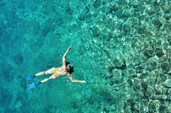 Mujer joven en traje de baño haciendo snorkel en un mar tropical poco profundo — Foto de Stock