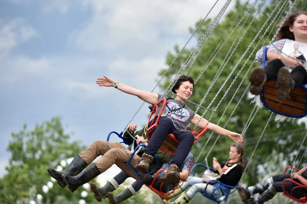 People in merry go round, swing ride, highland spinner — Stock Photo, Image