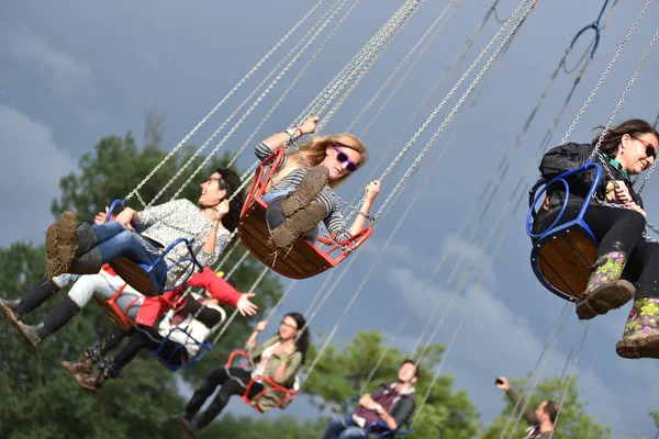 Människor i merry go round, swing Rida, highland spinner — Stockfoto