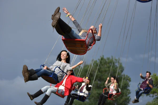 People in merry go round, swing ride, highland spinner — Stock Photo, Image