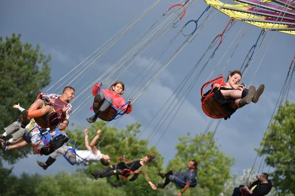 People in merry go round, swing ride, highland spinner — Stock Photo, Image