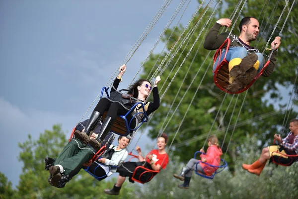 People in merry go round, swing ride, highland spinner — Stock Photo, Image