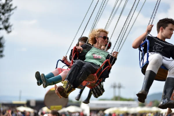 People in merry go round, swing ride, highland spinner — Stock Photo, Image