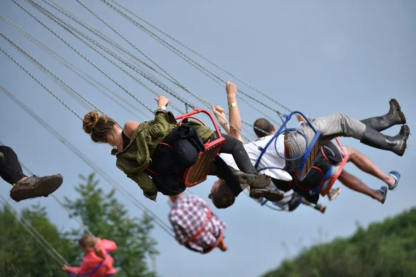 People in merry go round, swing ride, highland spinner — Stock Photo, Image