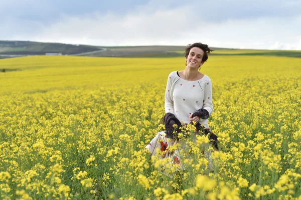 Beautiful woman cheering in rapeseed field and enjoying sunny su — Stock Photo, Image