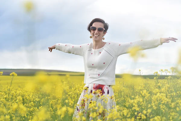 Красива жінка вітає в полі ріпаку і насолоджується сонячним су — стокове фото