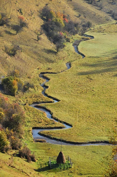 Pequeño curso de agua serpenteante en un prado verde — Foto de Stock