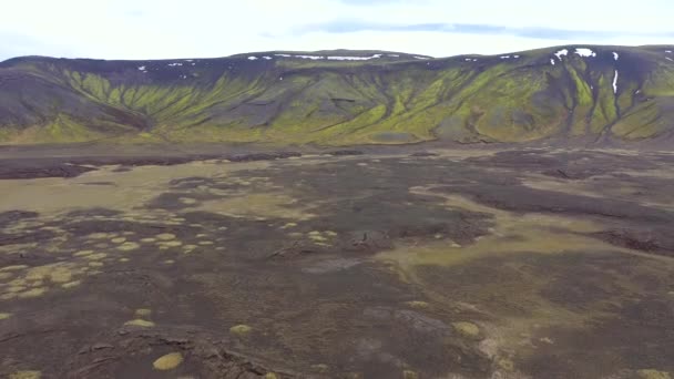 巨大な火山高原の上を飛んで アイスランドの鮮やかな緑の苔で溶岩の流れ — ストック動画