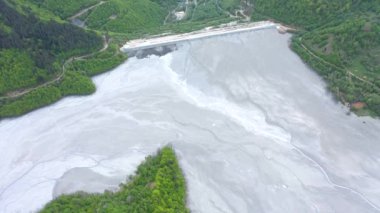 Madenci atıklarıyla dolu dev bir sürahi gölünün üzerinden uçarak yerleşim birikintisine akın ediyorlar. Geamana, Rosia Montana, Romanya 'nın hava manzarası