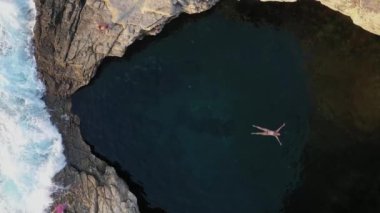 Yunanistan 'ın Thassos adasında, deniz kenarındaki doğal havuz, Giola lagününde yüzen ve yüzen bir kızın hava manzarasının üzerinde.