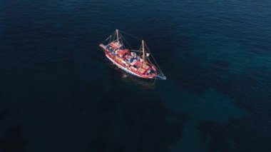 THASSOS, GREECE 2 Eylül 2019: Yunan adasının kayalık Akdeniz kıyıları yakınlarında yelken açan bir turist yolcu gemisinin hava görüntüsü