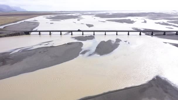 アイスランドの壮大な川を流れる橋の道路を通過する車の空中ビュー — ストック動画