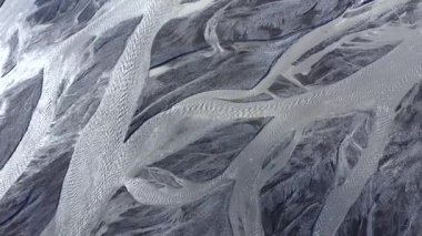 İzlanda 'daki buzul erimiş su nehirlerinin yukarıdan aşağıya bakış açısı soyut. İnsansız hava aracının yakaladığı destansı doğal manzara.