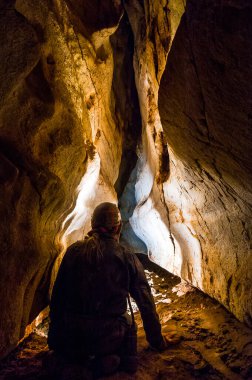 Mağarada eski tünelleri keşfeden bir mağara araştırmacısı yeni yeraltı geçitleri keşfediyor.