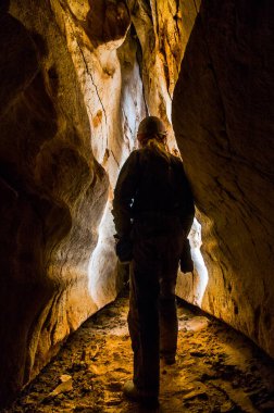 Speleolojist derin bir mağarayı keşfediyor.