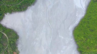 Madenci atıklarıyla dolu dev bir sürahi gölünün üzerinden uçarak yerleşim birikintisine akın ediyorlar. Geamana, Rosia Montana, Romanya 'nın hava manzarası