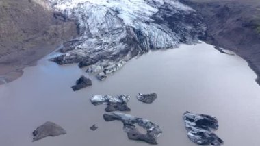 İzlanda 'daki eriyen Fjallsarlon buzulunun 4k hava aracı yüksek açılı görüntüsü. İklim değişikliği, eriyen buzullar, küresel ısınma kavramı