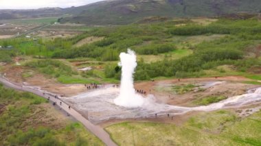 Suyun püskürmesi sırasında Strokkur geyiği üzerinde uçan, İzlanda, 4k hava aracı görüntüsü