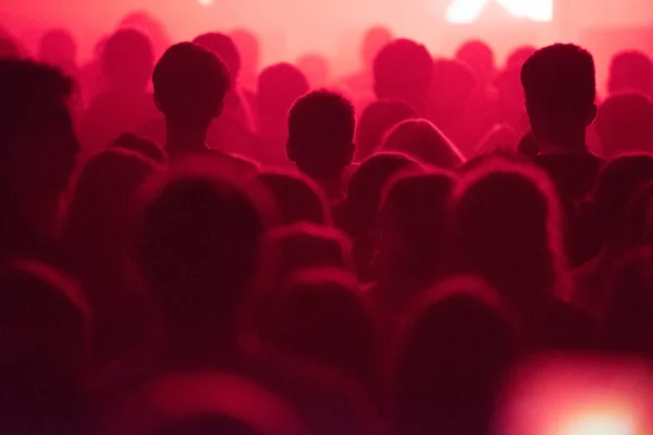 stock image Silhouette of concert crowd at music festival in red stage lights watching the show