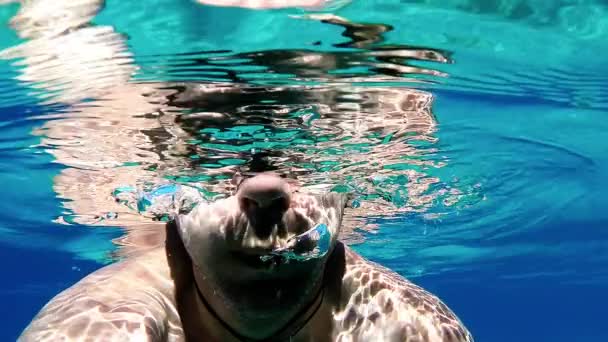 Медленное движение человека, выдыхающего пузырьки воздуха под водой — стоковое видео