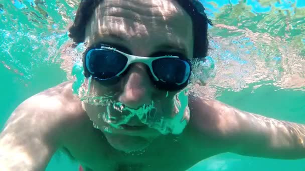 Slow motion of a man breathing out air bubbles underwater — Stock Video