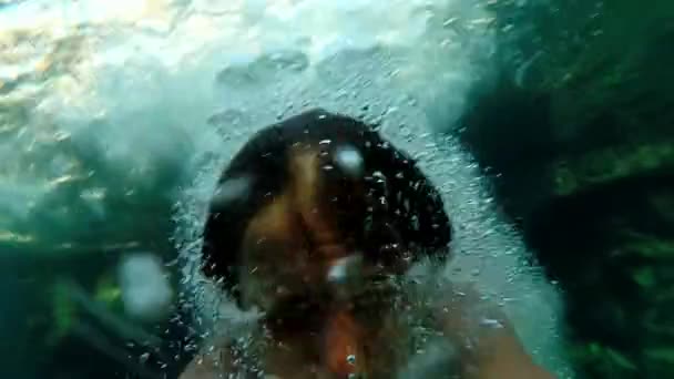 La cámara lenta de un hombre saltando en el agua - vista submarina — Vídeo de stock