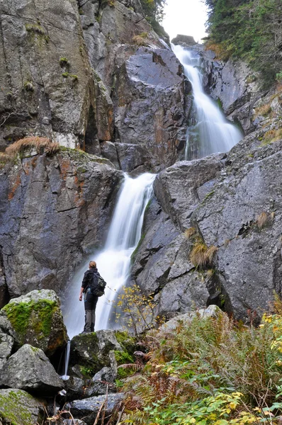 Турист стоїть перед водоспадом — стокове фото