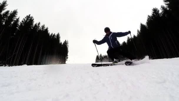 Långsam rörelse av en skidåkare skidåkning ner i backen — Stockvideo