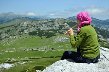 Flüt dağlarda oynayan kız