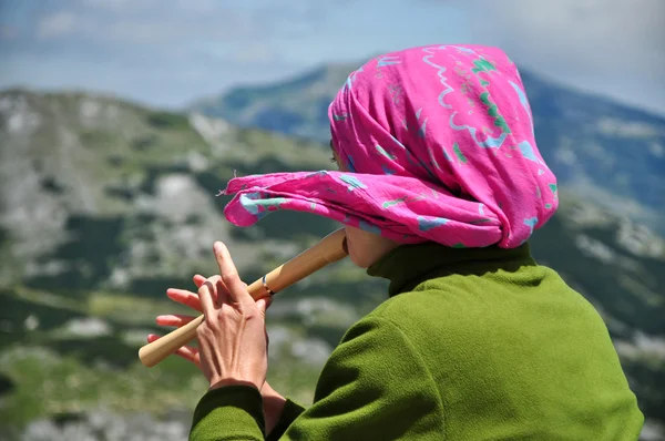 Fille jouer sur flûte dans les montagnes — Photo