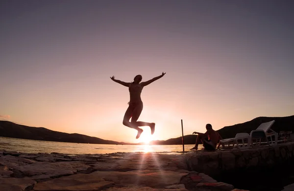 Mädchen springt bei Sonnenuntergang am Strand — Stockfoto