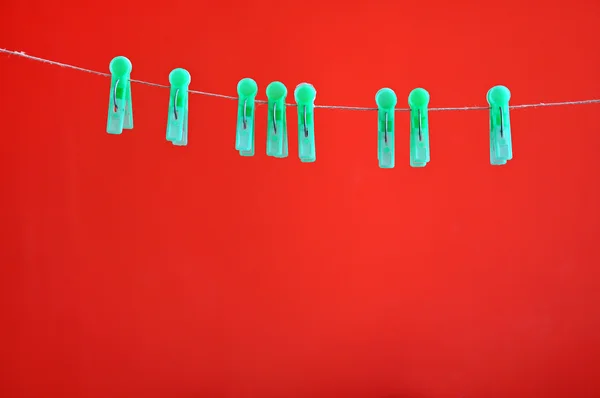 Green clothespins hanging on rope — Stock Photo, Image