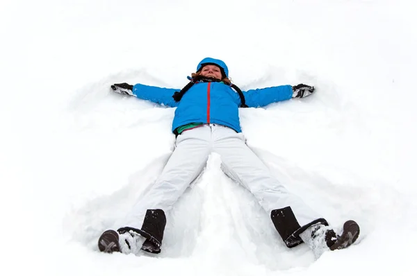 Menina bonita fazendo um anjo de neve de inverno — Fotografia de Stock