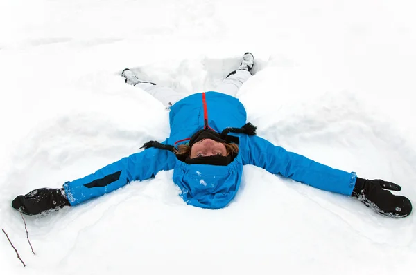 Menina bonita fazendo um anjo de neve de inverno — Fotografia de Stock