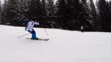 Kayakçı yamaçta kayak yapıyor.