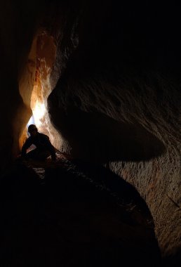 Spelunker exploring a cave clipart