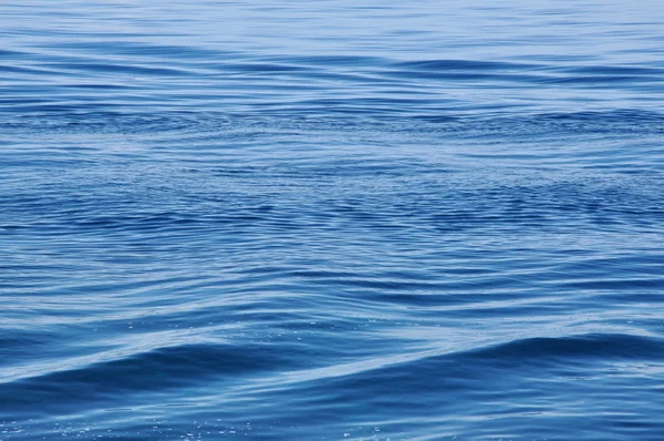 Wateroppervlak met golven en rimpelingen als achtergrond — Stockfoto