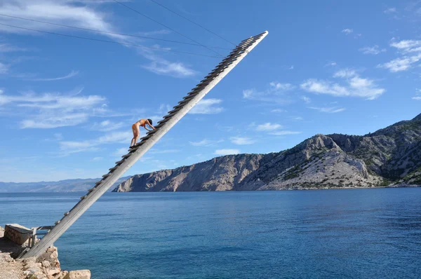 Salvavidas en una escalera de madera sobre el mar —  Fotos de Stock