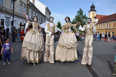 Artists on stilts performing in medieval costumes clipart