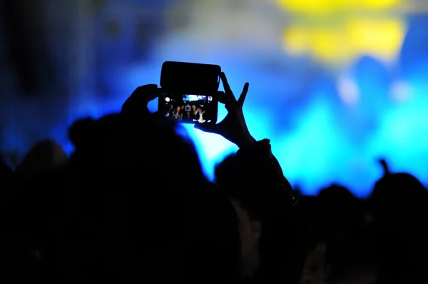 Multitud de personas tomando fotos con teléfonos inteligentes en un concierto — Foto de Stock