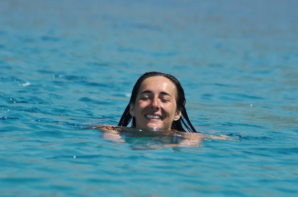 Beautiful young woman swimming in the sea — Stock Photo, Image