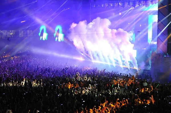 Толпа людей поднимает руки на концерте — стоковое фото
