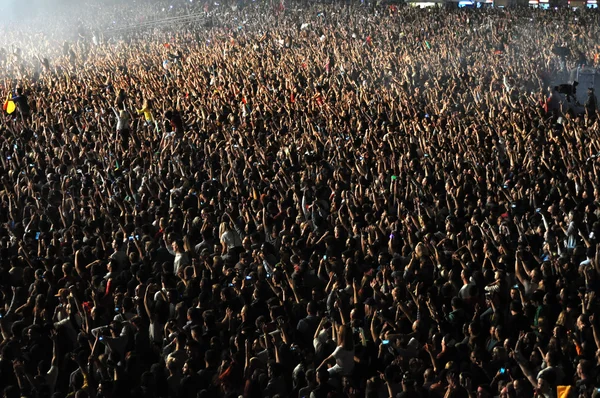 Une foule de gens levant la main à un concert — Photo